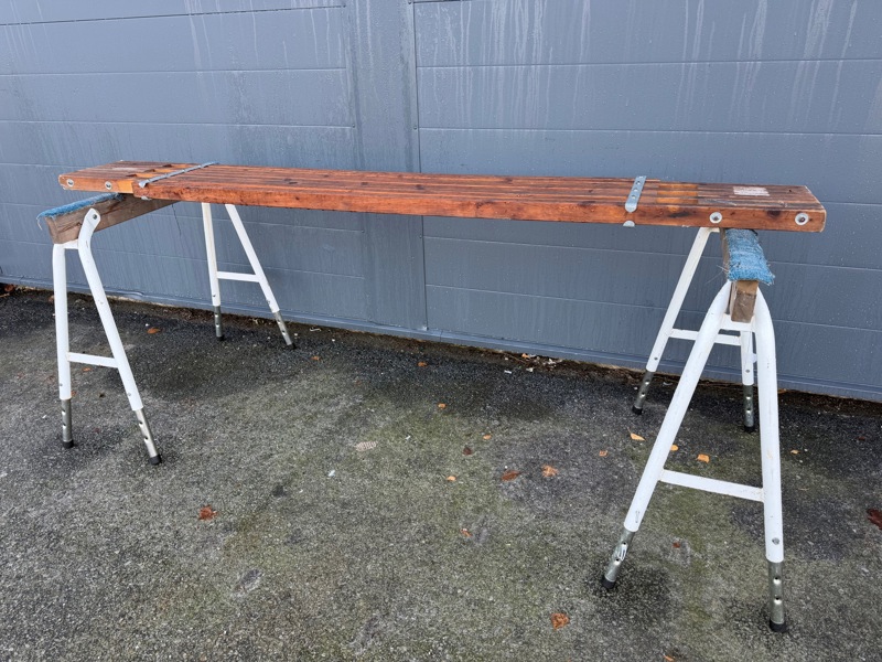 Bänk på bockar, trä/metall, justerbar längd.